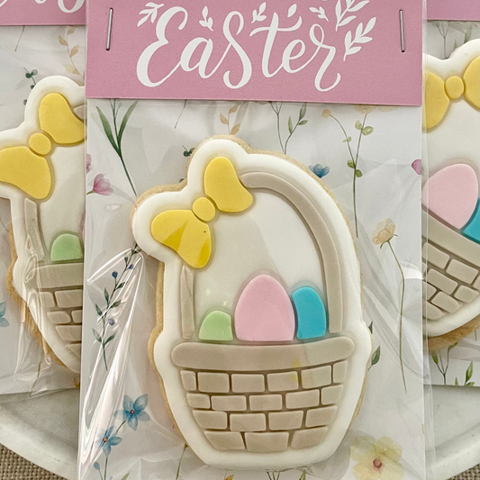 Cookie cutter shaped like an Easter basket with eggs, on a 'Happy Easter' themed card.