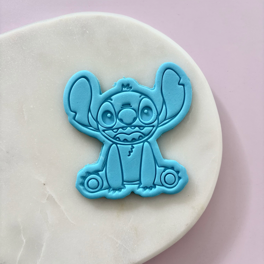 Blue cartoon character mold on a white surface with a light purple background