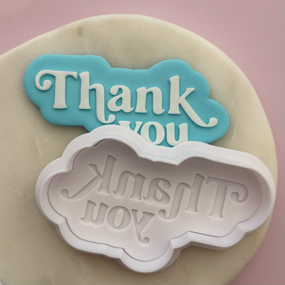 Cookie cutter with 'Thank you' on a pink background