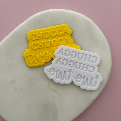 Two cookie stamps with text on a marble surface