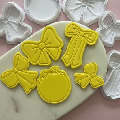 Yellow bow-shaped cookie cutters on a pink surface